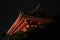 a tall red japanese traditional building illuminated by lights at night, kyoto