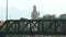 A tall religious sculpture behind a metal bridge