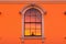 tall, rounded window reflecting the orange hues of sunrise on an italianate building