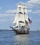 Tall ship with American flag sailing on blue waters