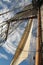 Tall ship mast and sail against blue sky
