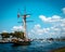 Tall ship setting sail from a harbor on a summer day