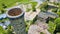 Tall silo smokestack aerial near abandoned, old, rubble building green ivy walls Pierceton IN