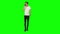 Tall skinny teen guy calmly walking and talking on the mobile phone on green screen. Chroma key, 4k shot. Front view.