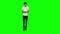 Tall skinny teen guy calmly walking and texting message vie his mobile phone on green screen. Chroma key. Front view.