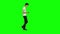 Tall skinny teen guy calmly walking and texting message vie his mobile phone on green screen. Chroma key. Profile view.