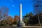 A tall slender stone monument to James Robertson the founder of Nashville on the edge of the lake