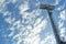 Tall spot lights tower of stadium with cloud and blue sky in background. Silhouette of spot light steel pole.