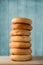 Tall Stack of Bagels on Wood with Turquoise Blue Plank Background