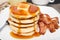 Tall stack of pancakes with bacon