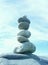 Tall stack pile of balanced stones rocks against blue sky