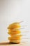 Tall Stack of Yellow Ice Lollies on White Tiled Background
