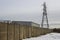 A tall steel electricity pylon with high voltage power cables that is part of the local grid supply network