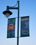 A tall streetlamp and rectangular blue banners showing a stylized crab and sea grass.