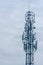 Tall telecommunication tower or transmitter broadcasting the internet network and mobile data at the cloudy sky background