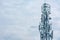 Tall telecommunication tower or transmitter broadcasting the internet network and mobile data at the cloudy sky background