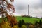 Tall telecommunications mobile and 5G cell tower on hill in fall