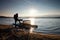 Tall tourist with backpack walk on beach at pedal boat in the sunset. Autumn at sea