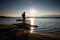 Tall tourist with backpack walk on beach at pedal boat in the sunset. Autumn at sea