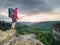 Tall tourist with big backpack looking in paper map. Wild hilly nature park. Hiker looking for new locations and landmarks to