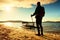 Tall tourist walk on beach at paddle boat in the sunset