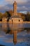 a tall tower with a clock on it in the middle of a lake