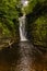 Tall waterfall in a canyon surrounded by green foliage Sgwd Einion Gam, Waterfall Country, Wales
