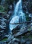 a tall waterfall cascading down around frozen rocks