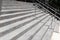 Tall wide concrete staircase on a building exterior, silver stainless railings