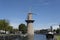 Tall wind mill near water canal and alley in Schiedam, Holland