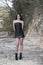Tall woman wear black leather strapless short dress and high heels pose outdoor