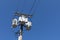 Tall wood electric pole with three transformers against a clear, deep blue sky