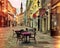 Tallinn Estonia medieval town  Rainy   evening in city street cafe tables empty on old pavement people walking  blurred light