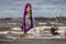 Tallinn, Estonia - October 18, 2008: Windsurfers and kitesurfers in protective suits ride along the waves of the sea.