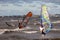 Tallinn, Estonia - October 18, 2008: Windsurfers in suits ride on boards with a sail on the waves on the sea in windy weather.