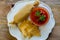 Tamale served with hot tomato sauce and tortillas on Wooden table