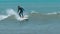 Tamarin, Mauritius, February 22, 2022: A surfer rides on a longboard along a wave.