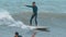 Tamarin, Mauritius, February 22, 2022: A surfer rides on a longboard along a wave.