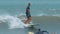Tamarin, Mauritius, February 22, 2022: A surfer rides on a longboard along a wave.