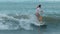 Tamarin, Mauritius, February 22, 2022: A surfer rides on a longboard along a wave.