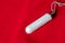 Tampon on a red background, close up, top view, menstrual period