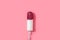 Tampon with red glitter on pink background.