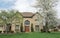 Tan Brick House with Topiary Shrubs & Flowering Pear Tree