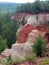 Tan and orange rock cliff canyon with trees