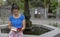 Tan Student reading a book sitting in a fountain waiting for friends from the university. Lady read a textbook in her free time to