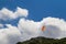 Tandem orange paragliding against a blue cloudy sky, sunny day.