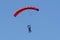 Tandem parachute jump. Silhouette of skydiver flying in blue clear sky