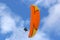 Tandem Paraglider flying orange wing