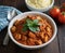 tandoori chicken with masala, ginger garlic cloves , cooked with garam and olive oil, bowl on the table with cherry tomatoes