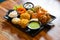 tandoori fried roasted momos dimsum pakora with vegetable flower chicken and green, white and red sauce put in a black
